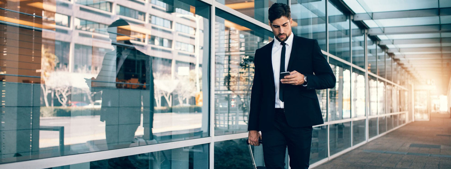 a person in a suit walking with his luggage