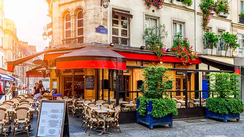 Cozy street with tables of cafe in Paris, France