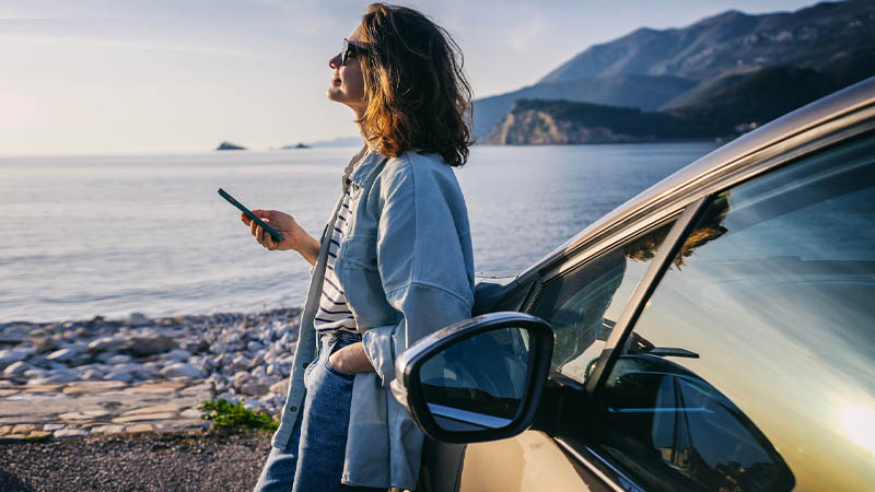 A woman leaning on the car